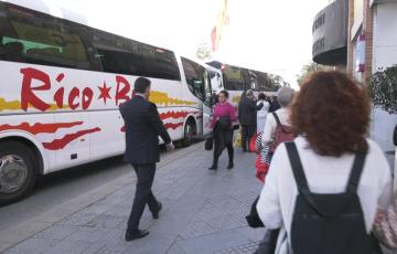 Ponentes descienden de los autobuses en el Palacio de Congresos 