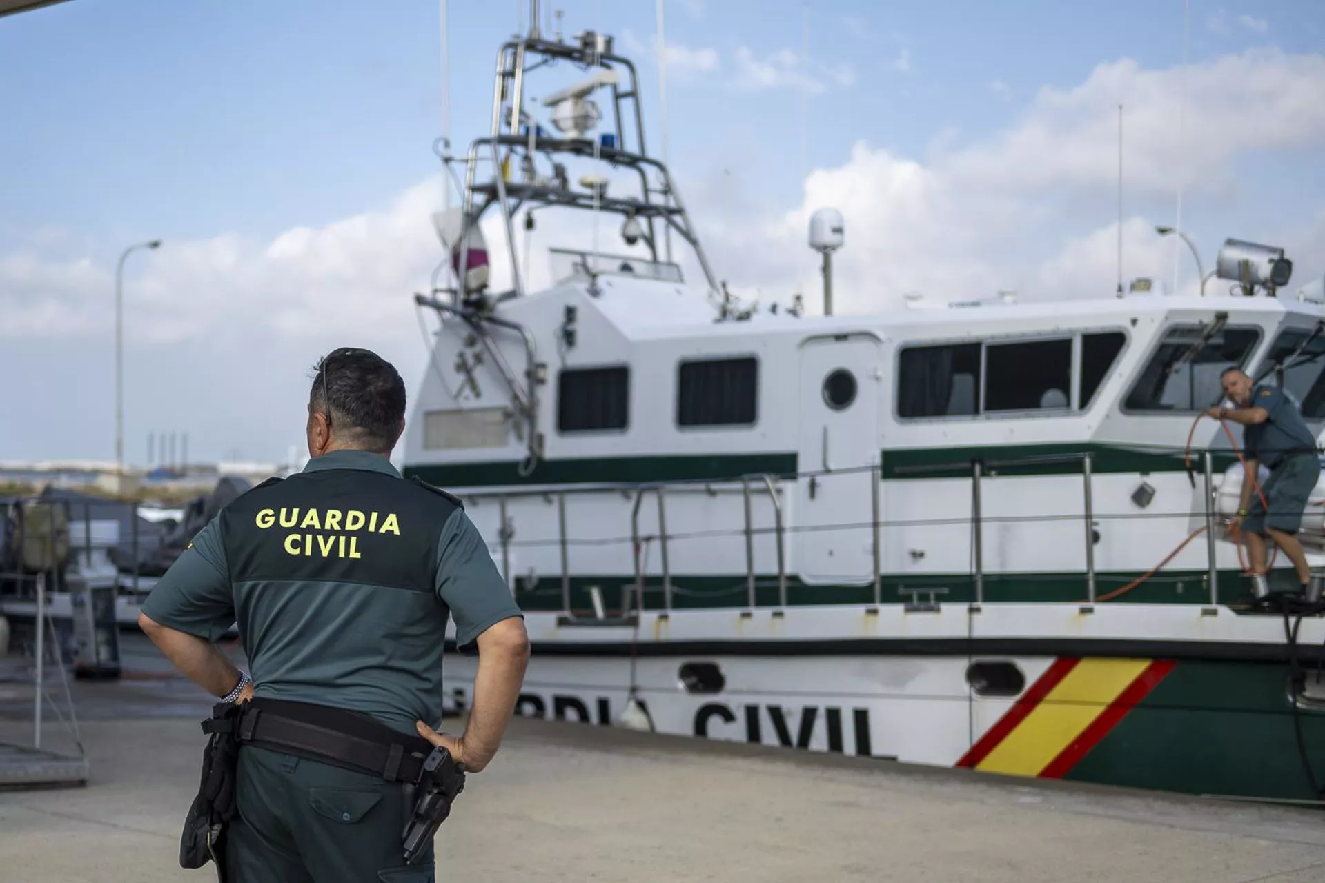 Un agente de la Guardia Civil delante de una embarcación del Servicio Marítimo.