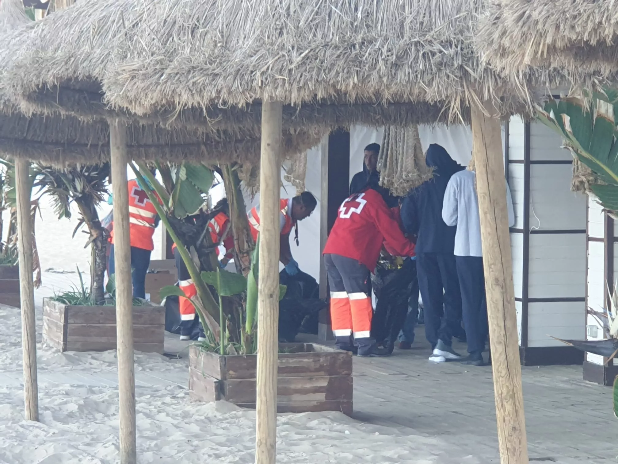 Miembros de Protección Civil y Cruz Roja socorren algunos de los desembarcados poco después de arribar a la costa