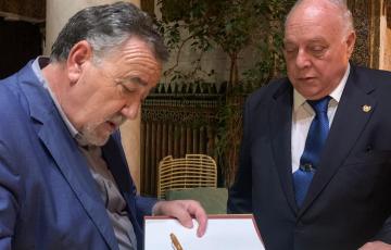 El escrito Jesús Maeso firmando un ejemplar a Guillermo Boto.