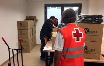 Miembros de Cruz Roja almacenan ropa de otra campaña