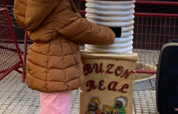 Una niña introduciendo su carta a los Reyes Magos en el buzón situado en la plaza de san Francisco