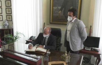 El ministro de Justicia, Juan Carlos Campo, firma el libro del visitas del Ayuntamiento junto al alcalde 