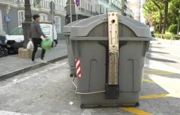 Un ciudadano deposita basura en un contenedor del casco antiguo de Cádiz