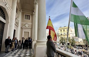 El acalde de Cádiz, junto a miembros de la Corporación municipal, durante la interpretación del himno de Andalucía en el balcón del Ayuntamiento