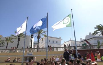 Momento en el que el alcalde, Bruno García, ha izado las banderas en La Caleta 