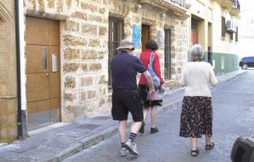 Varios turistas pasan por delante de un inmueble de Viviendas con Fines Turísticas  (VFT)