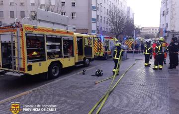 Una dotación de bomberos trabaja en la extinción del incendio en un piso de la calle Grazalema de la ciudad. 