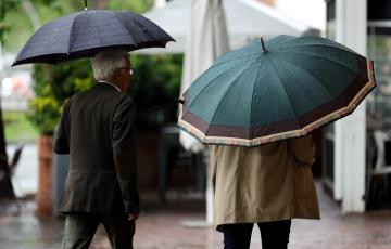 Dos viandantes se protegen de las fuertes lluvias en una imagen de archivo