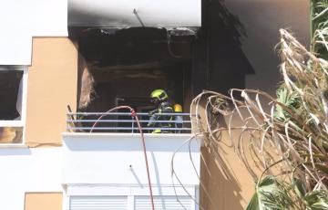 Efectivos de los bomberos actuando en el incendio en una vivienda de la barriada de la Paz.