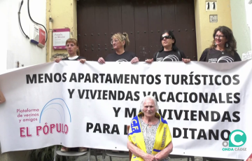 María, la vecina salvada del desahucio de su casa junto a la pancarta de la protesta