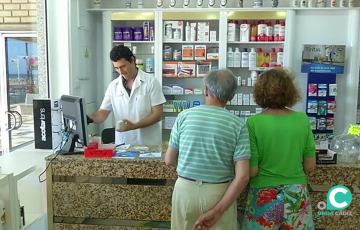 Un farmaceutico atiende a unos clientes en una botica de Cádz