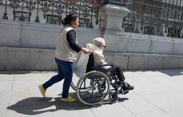  Una mujer mayor en silla de ruedas y su cuidadora 