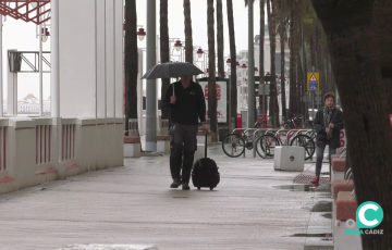 Un viandante se resguarda de la lluvia en Cádiz. 