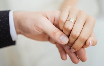 Una pareja cogida de la mano en su boda