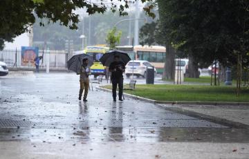 Transeuntes bajo sus paraguas durante la intensa lluvia en Canalejas