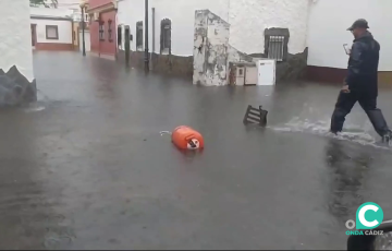 Un hombre se abre paso por una calle inundada en una barriada isleña.