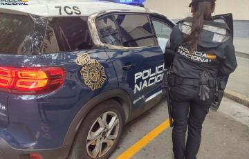 Una agente de la Policía Nacional junto a un coche patrulla en una imagen de archivo