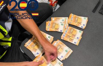 Un agente contando dinero incautado durante las acciones policiales