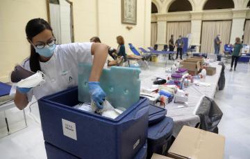 Una enfermera deposita las bolsas de sangre en un contenedor frigorífico