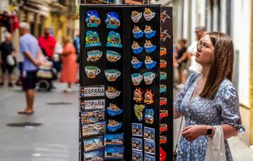 Una persona mirando una tienda de recuerdos tuísticos de Cádiz