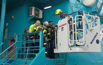 Efectivos de Bomberos y Policía Portuaria ayudan a desembarcar a los pasajeros del buque averiado en Tarifa.