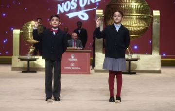 Dos niños del Colegio de San Ildefonso, cantan el tercer premio durante el sorteo