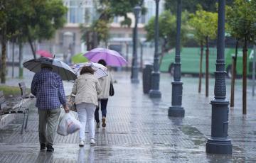 Transeúntes bajo sus paraguas durante una intensa lluvia en Cádiz.