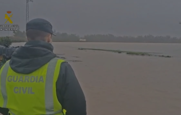 Un guardia civil observa la zona inundada por el rio Guadalete en el termino de Jerez