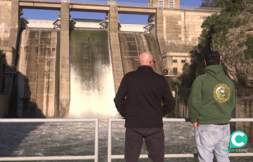 Dos personas observan la caida de agua de los Hurones