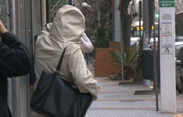Viandantes dse protegen del viento y la lluvia en la capital gaditana