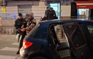 Agentes escoltan a uno de los arrestados en el operativo