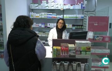 Una profesional atiende a una paciente en una farmacia de Cádiz. 