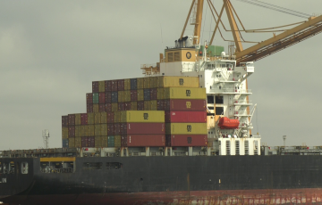 Barco csrgado de contenedores de mercancías en el muelle de la capital gaditana