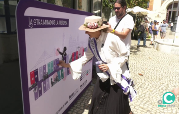 Una sufragista marca el mural de línea de tiempo instalado en la capital gaditana.