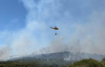 Un helicóptero del Plan Infoca descargando agua sobre el lugar del siniestro