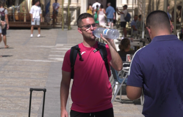 Un viandante se hidrata en la plaza de la Catedral de la capital gaditana