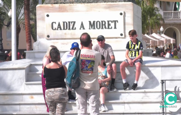 Una familia se fotografía en el monumento a Moret en la plaza San Juan de Dios