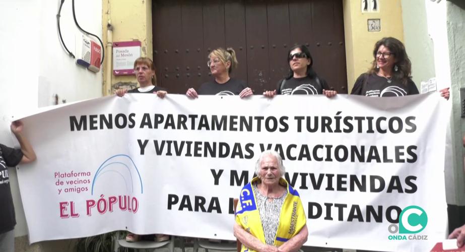 María, la vecina salvada del desahucio de su casa junto a la pancarta de la protesta