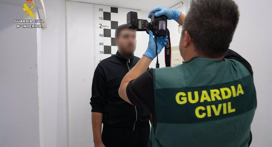 Un agente de la Guardia Civil toma fotografías al detenido, Karim E.B.