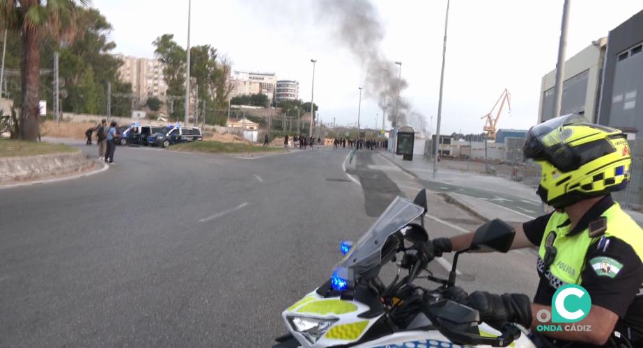 Un agente de Policía Local observan piquetes en la rotonda de la carretera industrial.