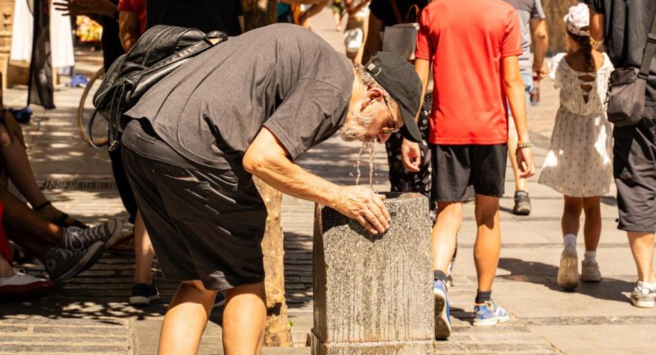 Turista se refresca con agua para hacer frente a las altas temperaturas, en una imagen de archivo.