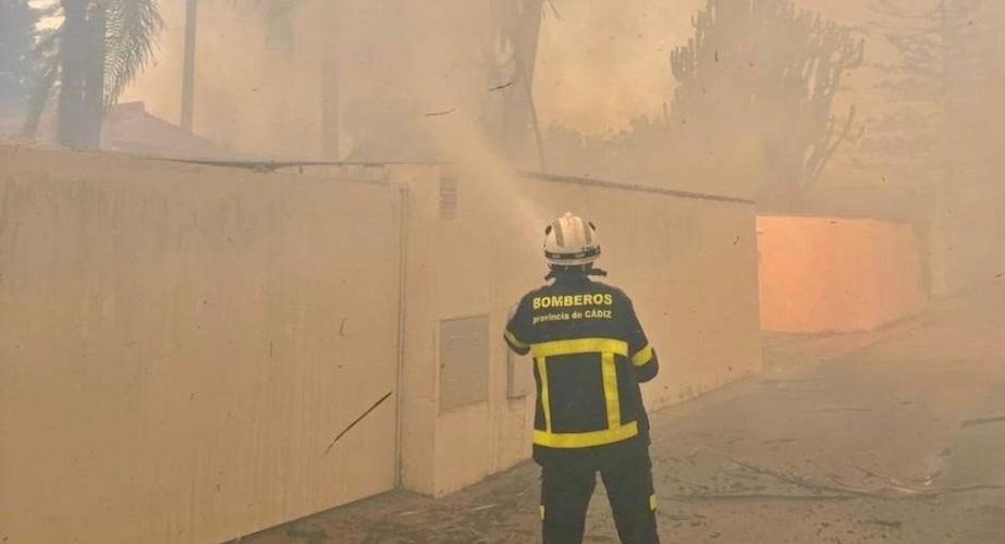 Un bombero intenta sofocar el fuego sobre la arboleda de la zona