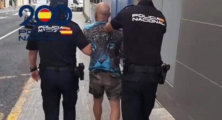 Dos policías escoltan a uno de los detenidos durante la mañana de este martes