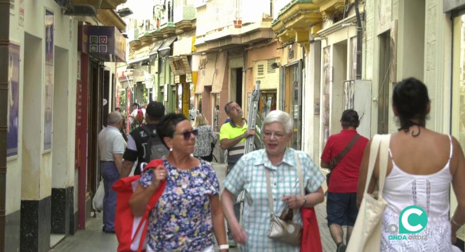 VIandantes por una calle de establecimientos comerciales por el centro de la ciudad