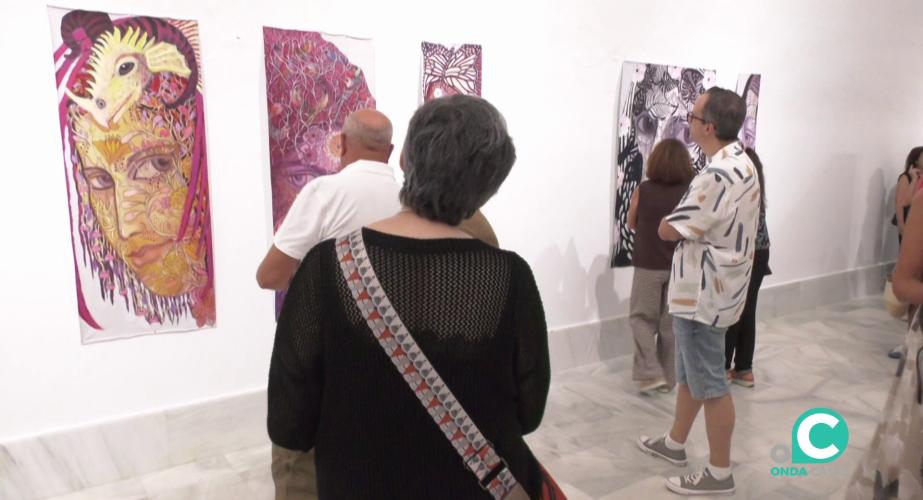 Visitantes en la jornada observan las obras durante la inauguración de la muestra