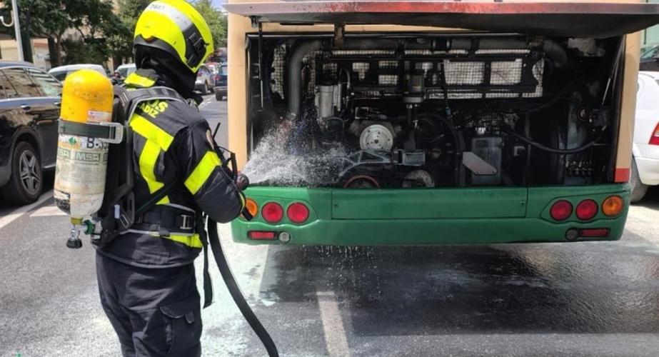 Bomberos sofocan el incendio originado en el motor del autobús urbano. 