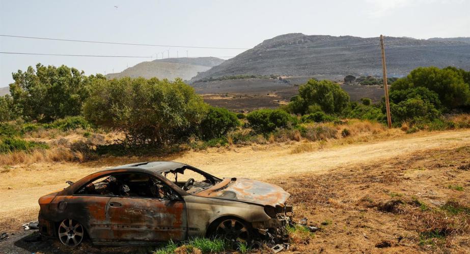 Vegetación y coche calcinado por las llamas en el lugar del siniestro