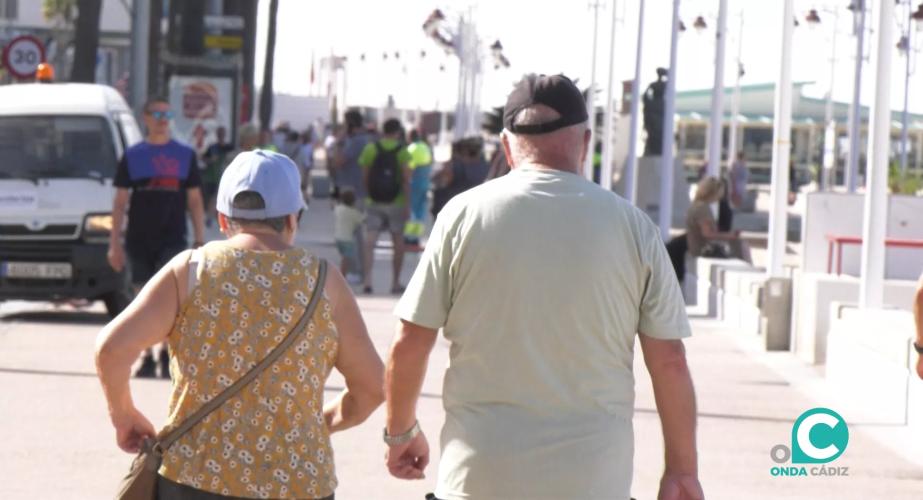 Viandantes paseando por el paseo marítimo de Cádiz. 