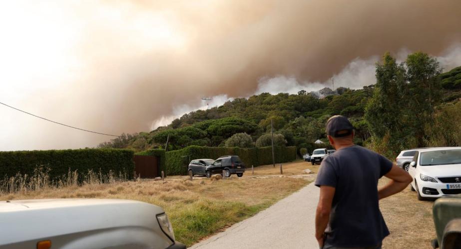 Una persona observa las columnas de humo originadas por el siniestro.